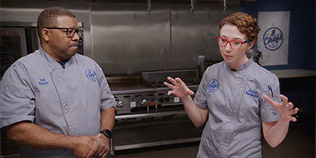 Chef Jessie and Chef Ted discussing their plan in the kitchen.